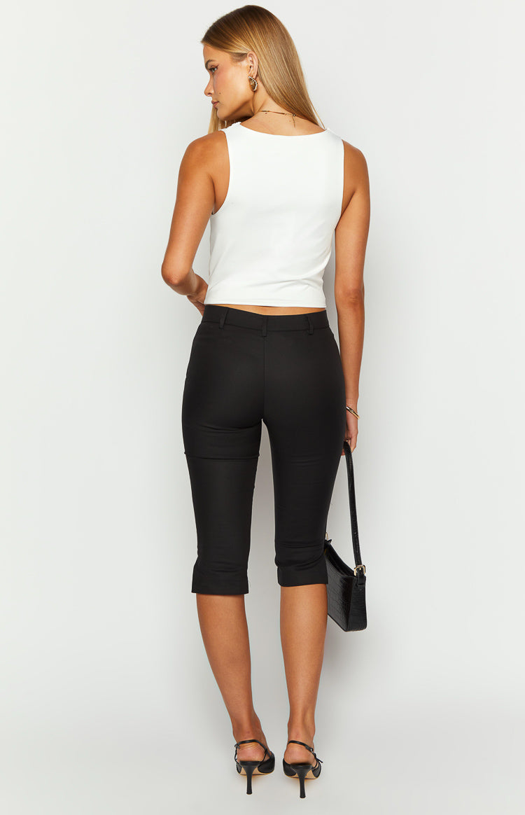 Back view of black capri pants, fitted through the leg with a cuffed hem detail at mid-calf