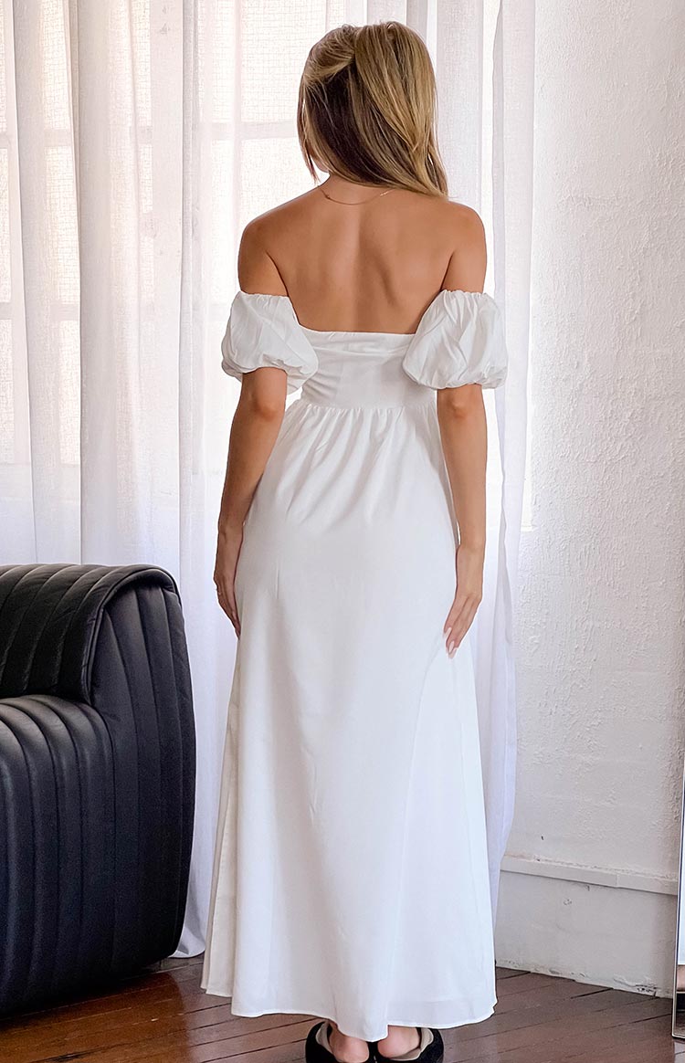 Rear view of a white off-the-shoulder maxi dress with puffed sleeves and a fitted bodice flowing into a relaxed skirt