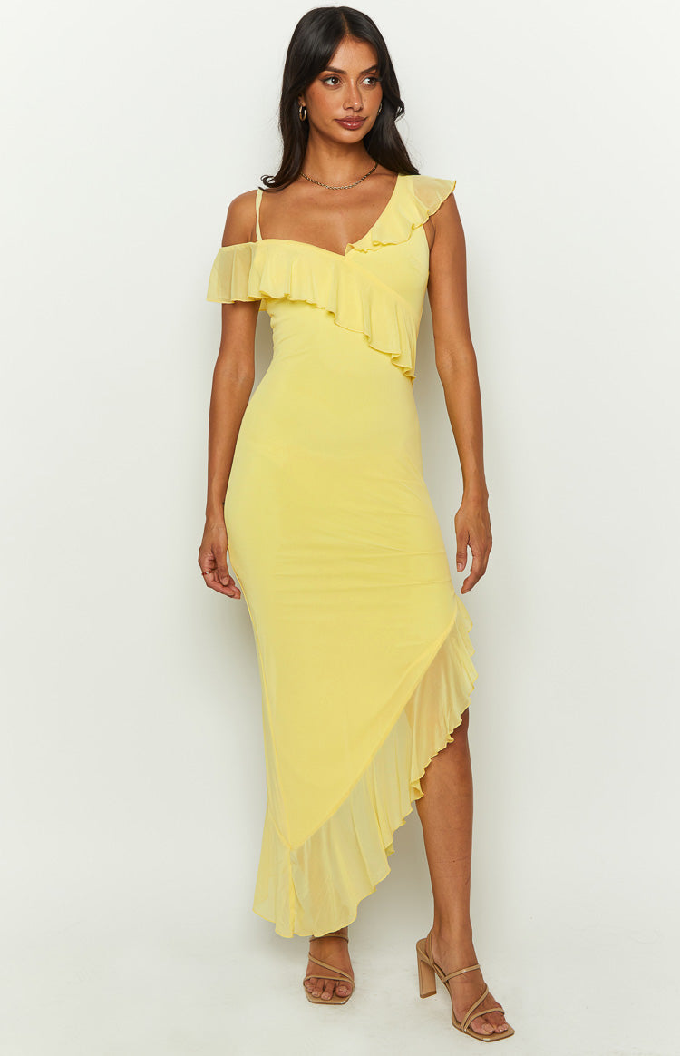 Full length front view of a yellow mesh midi dress with an asymmetrical ruffle neckline and diagonal ruffle hem