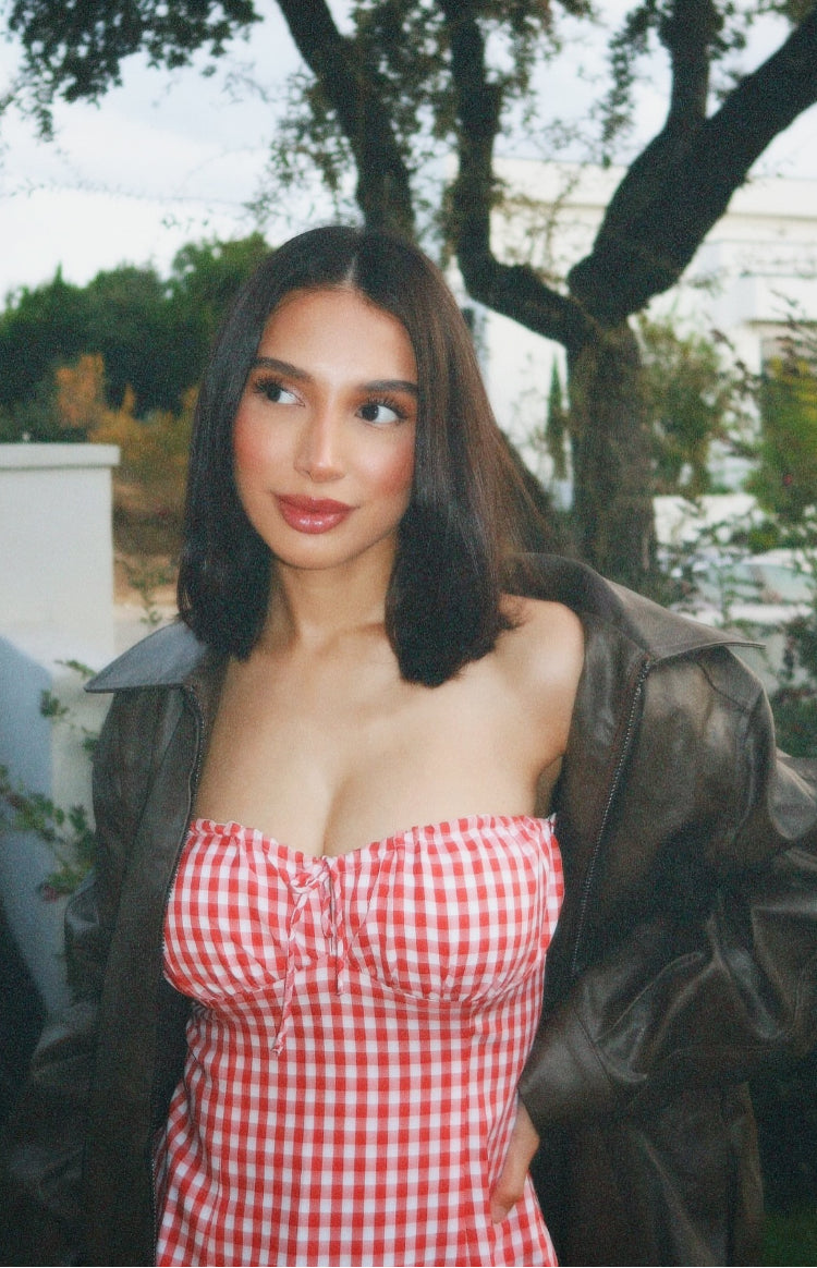 Close-up of the red gingham strapless mini dress showing the ruched bust and tie-front detail