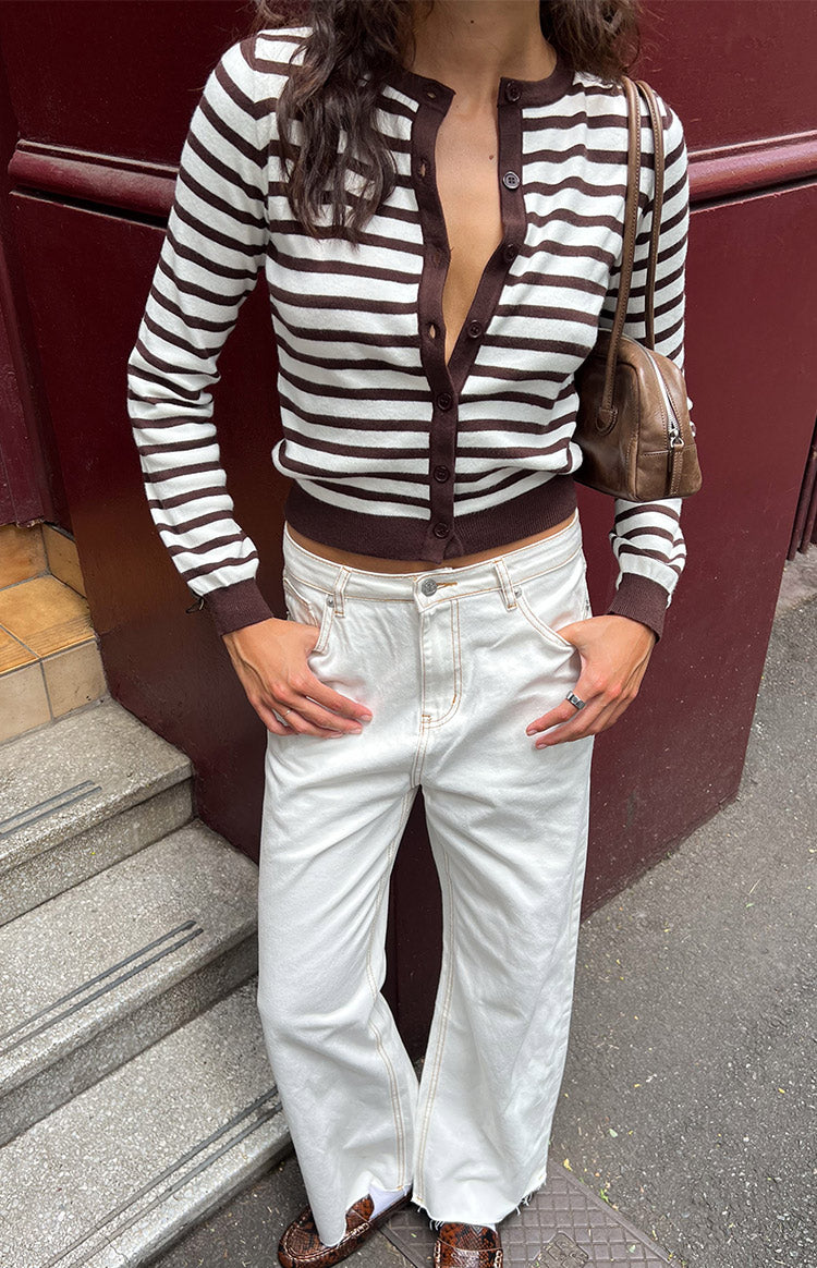 Relaxed fit white wide-leg denim jeans with visible contrast tan stitching and a raw frayed hem