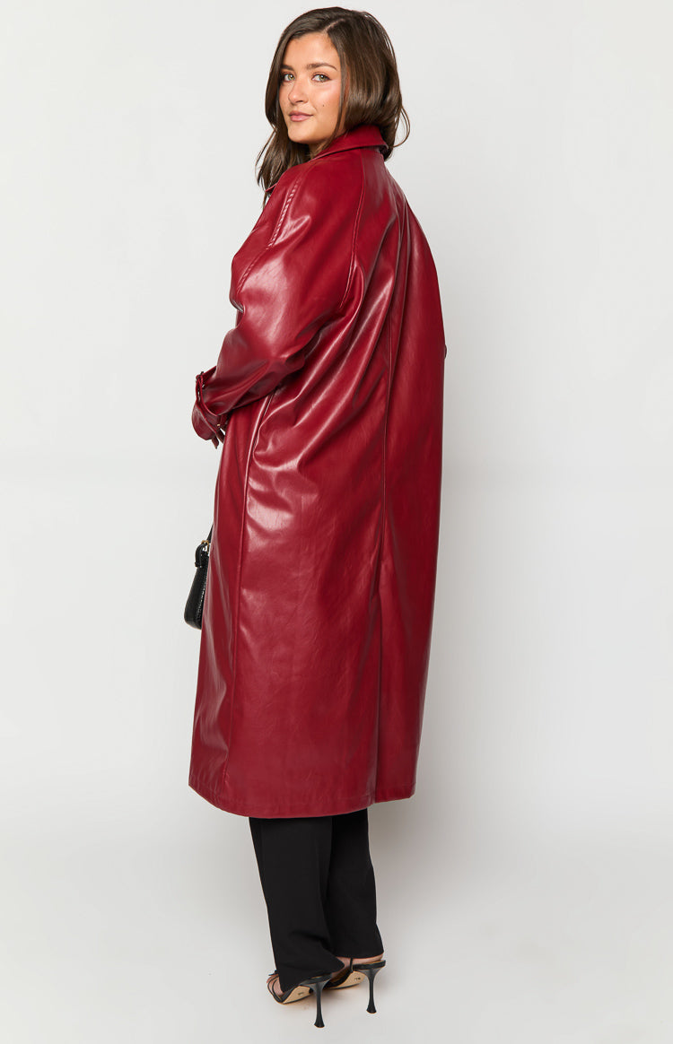 Side view of a long red PU trench coat with a relaxed silhouette and smooth finish