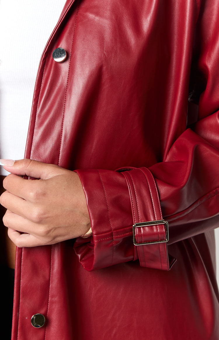 Close-up of the red PU coat's sleeve cuff with a silver buckle and front placket buttons