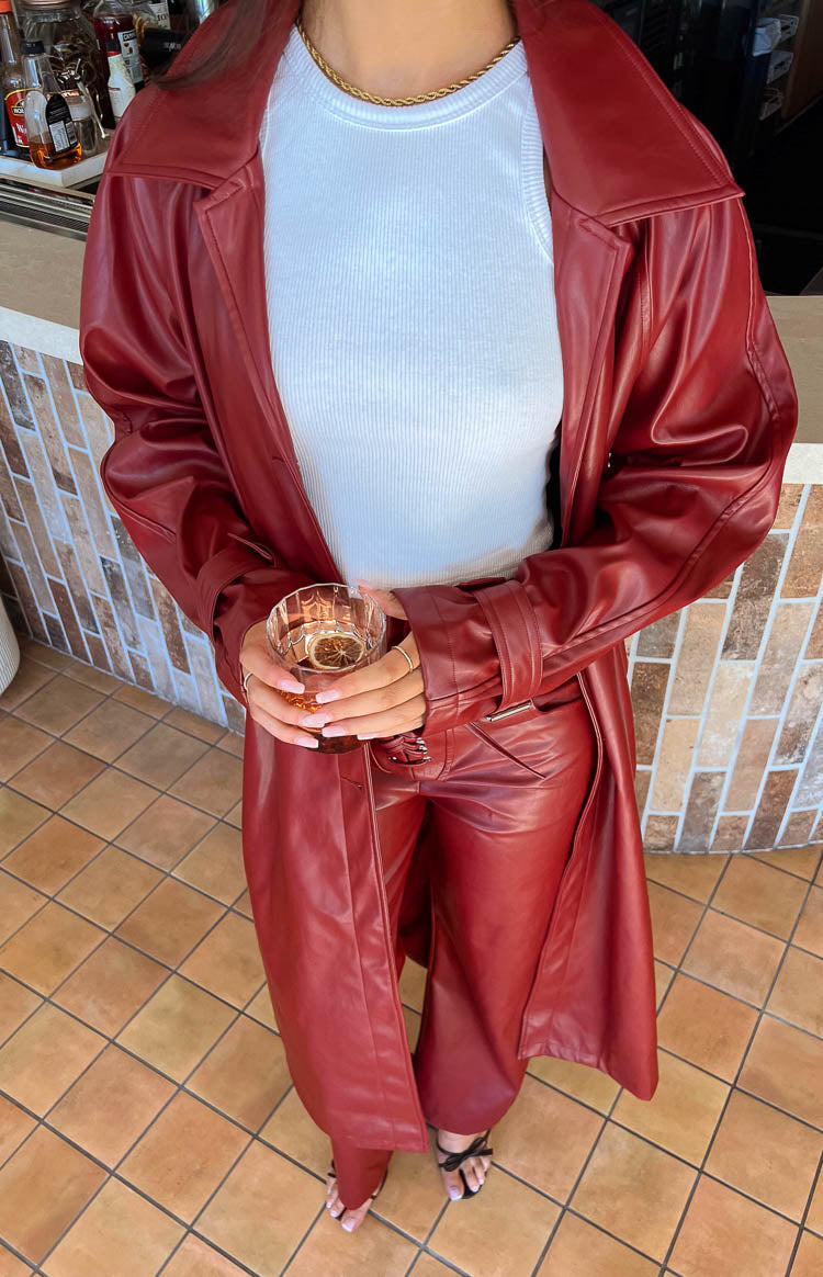 Red PU trench coat worn open, paired with matching red PU pants and adjustable cuff straps