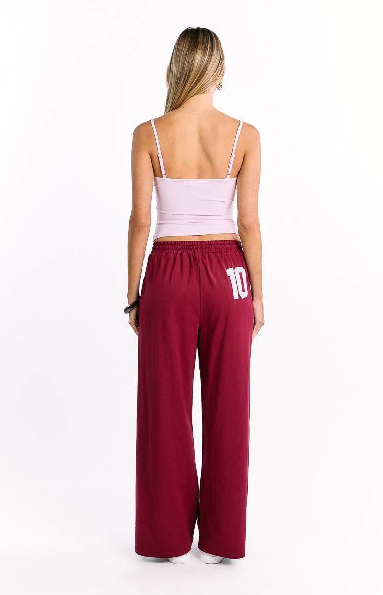 Rear view of burgundy wide leg pants showing the elasticated waistband and white number 10 graphic