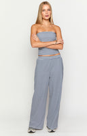 Model is wearing a navy and white horizontally striped strapless tube top with matching high-waisted- wide-leg pants.