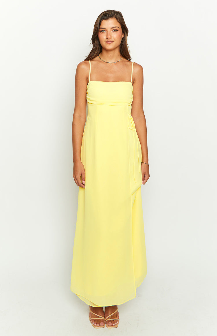 Front view of a yellow maxi dress with a straight neckline, thin spaghetti straps, and a tie-side detail at the waist