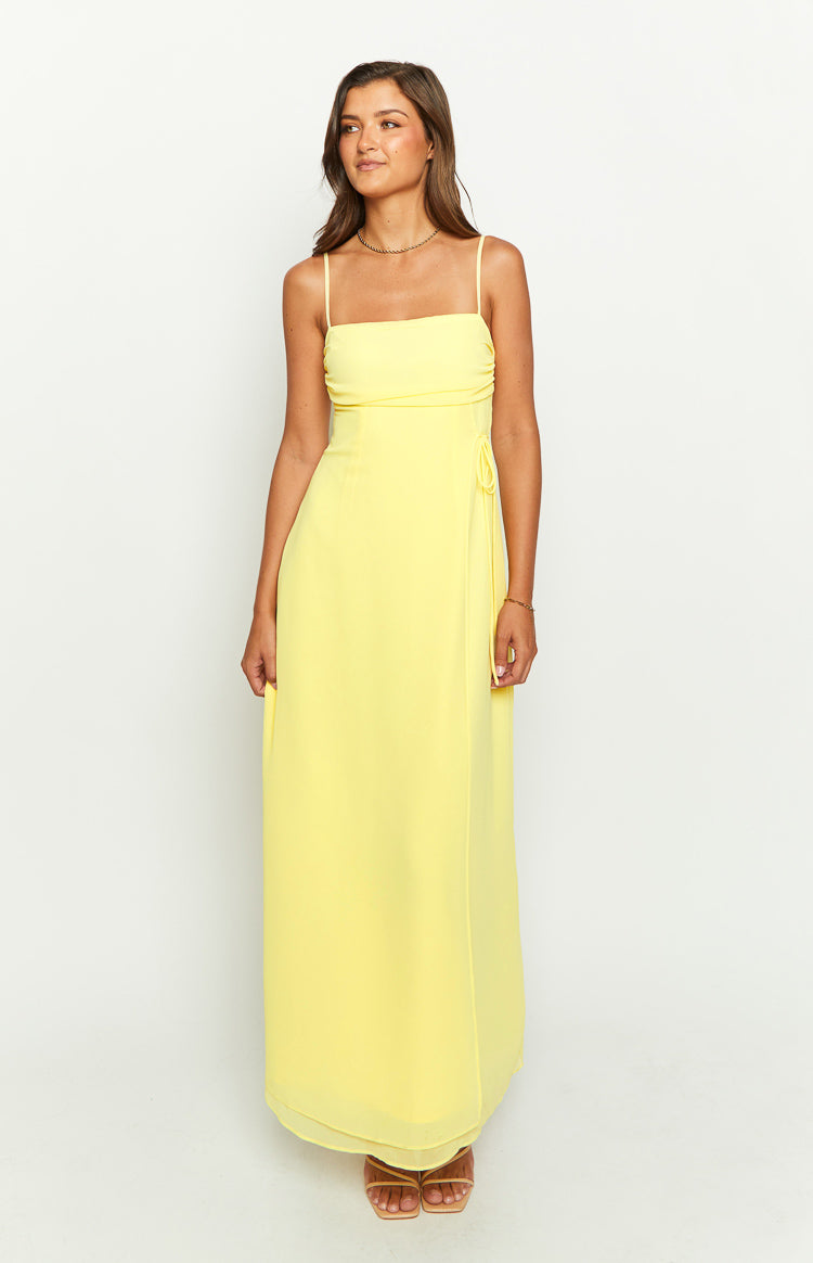Front view of a yellow maxi dress with a straight neckline, spaghetti straps, and side tie detail