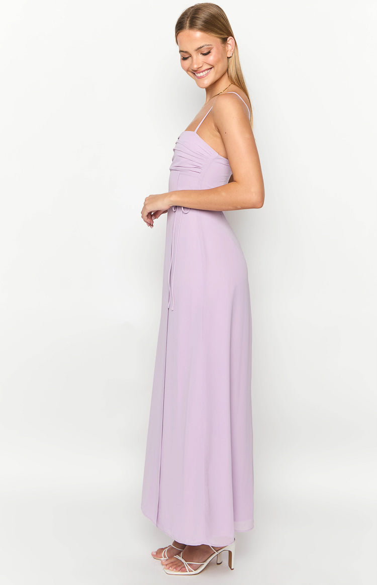 Side view of a lilac maxi dress with a ruched bust, thin spaghetti straps, and a side tie detail at the waist
