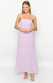 Lilac maxi dress with a square neckline, thin spaghetti straps, ruched bodice, and a wrap-style skirt with tie detail