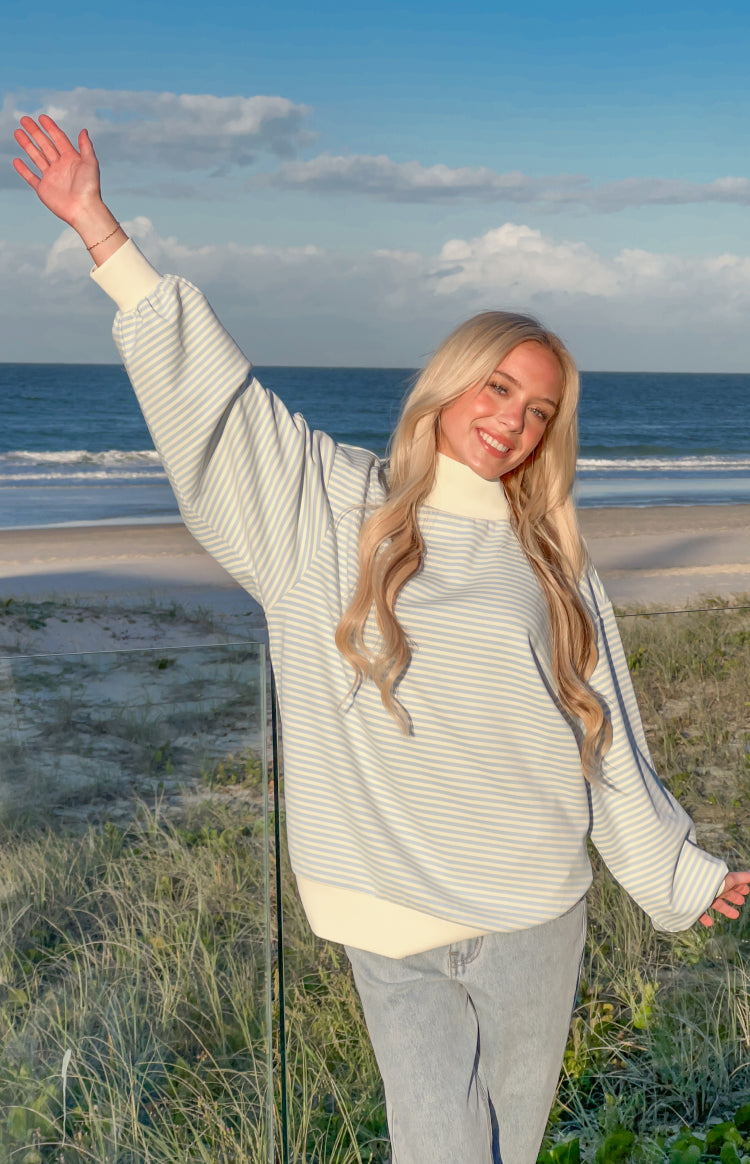 Blue and white stripe mock neck sweater featuring oversized balloon sleeves and a wide ribbed hem