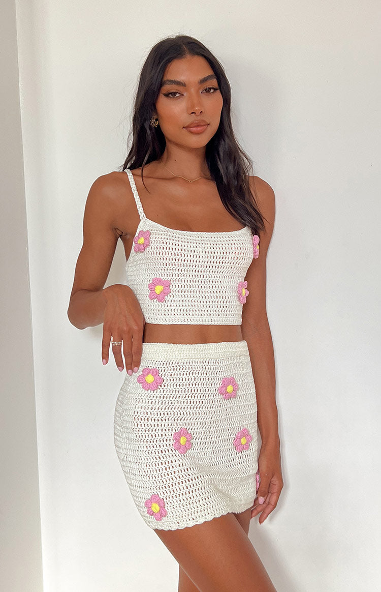White crochet crop top with square neckline, thin spaghetti straps, and pink and yellow flower appliques