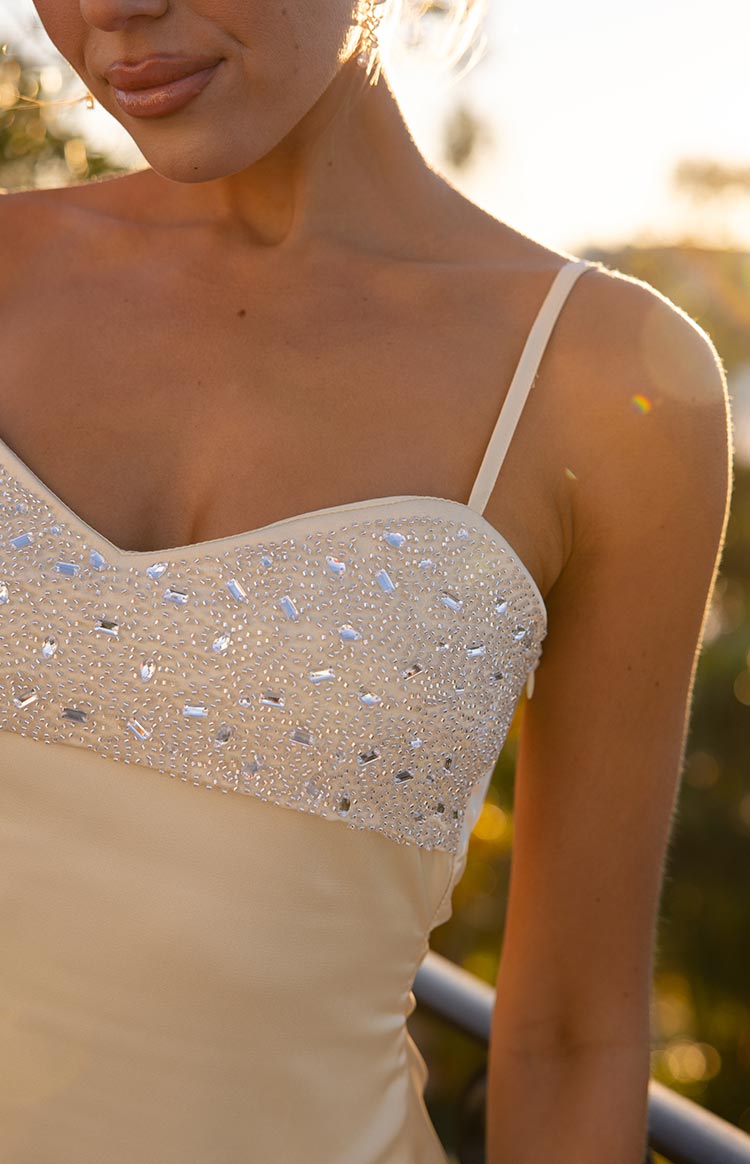 Close-up of the sweetheart neckline and intricate silver beading and sequins on the cream bodice of the mini dress
