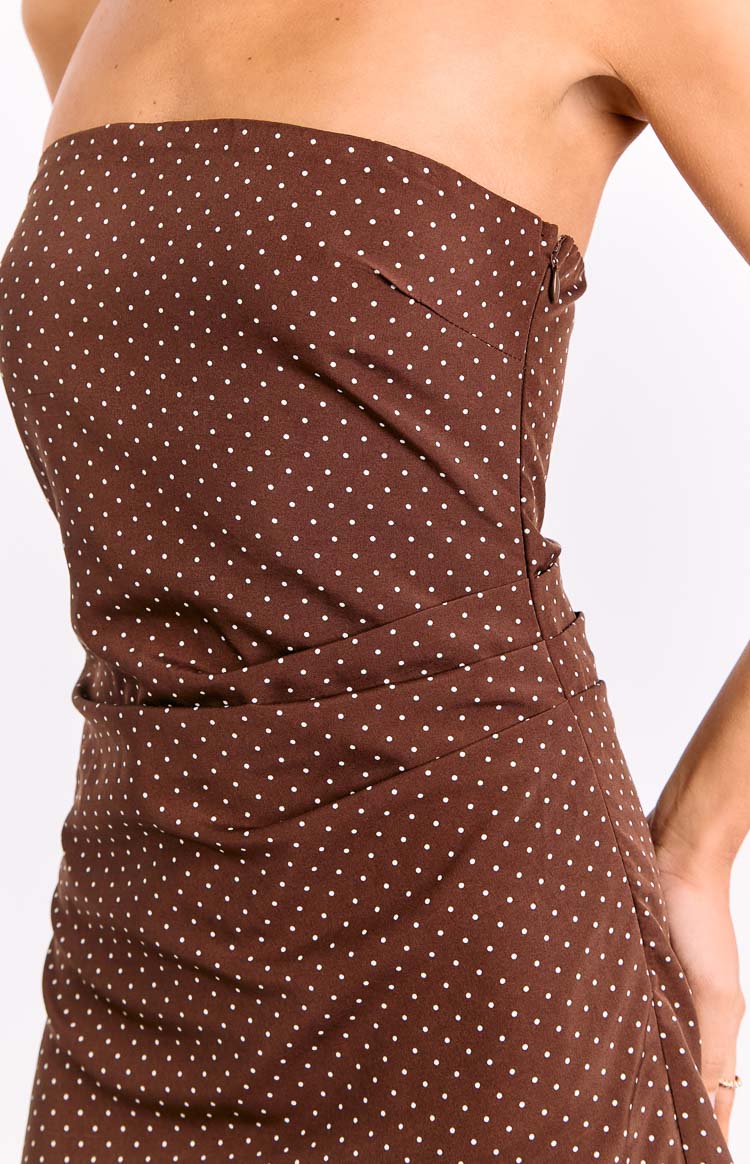 Close-up side view of a brown polka dot mini dress showing the ruched detailing and a visible side zipper