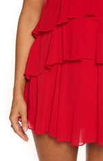 Detail shot of the layered ruffles and sheer hem of the red mini dress