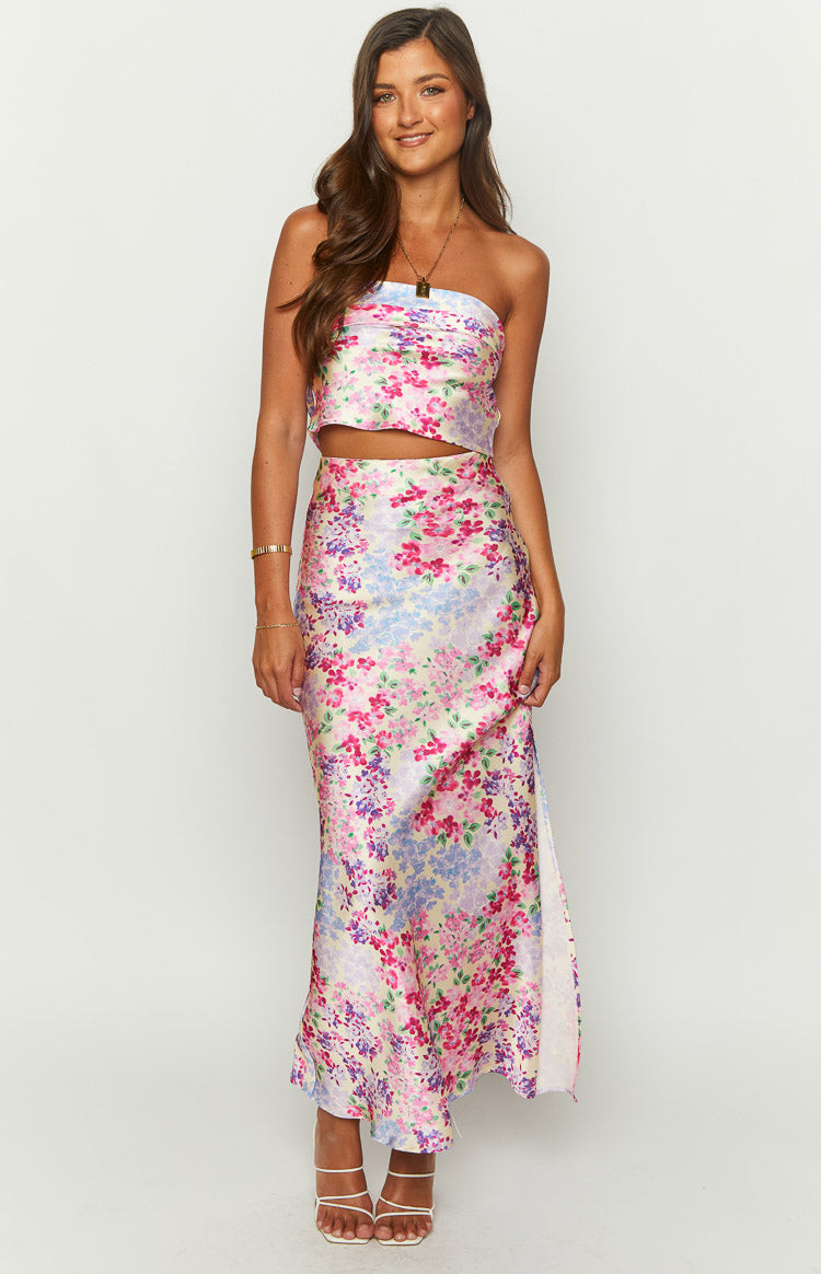 Front view of a pale yellow maxi skirt with a vibrant pink, purple, and blue floral print and a high side slit