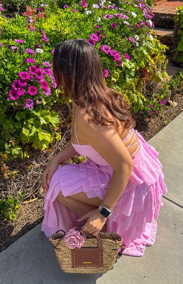 Side view of a pink ruffle maxi dress showing the tiered skirt and thin lace-up back straps