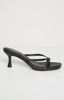 A single black heeled sandal with thin straps is shown on a light background. The sandal has a square toe and a small, curved heel.