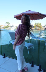 Side view of a pink and maroon horizontal striped oversized tee with short sleeves