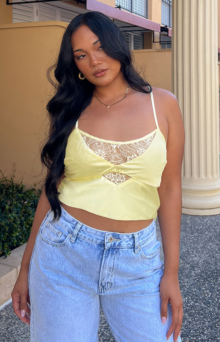 Yellow satin crop top with white lace V-neck, triangle cutout, and thin spaghetti straps