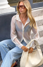 Front view of a cream sheer button through shirt with a classic collar and long cuffed sleeves
