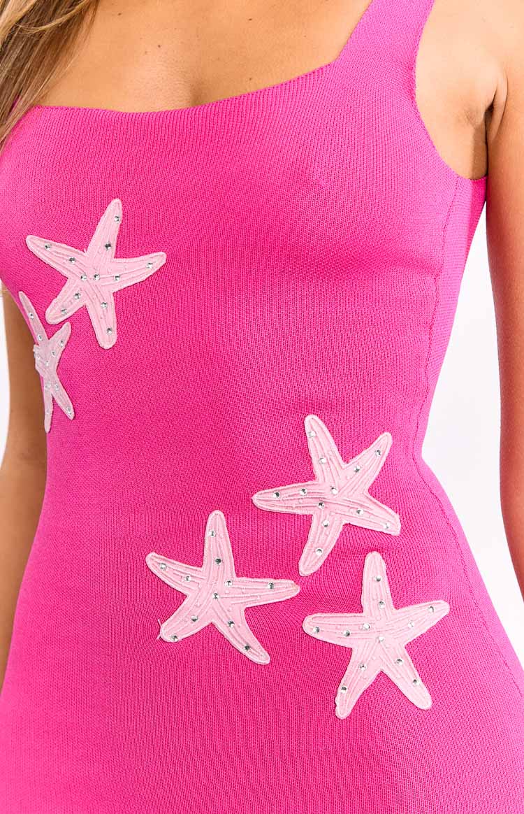 Detail shot of the hot pink knit mini dress with a square neckline and light pink starfish appliques embellished with silver studs