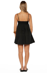 Rear view of a black mini dress with a straight back, adjustable spaghetti straps, and a gathered A-line skirt