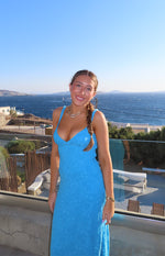 Fitted blue floral lace maxi dress with a deep V-neckline and thin shoulder straps