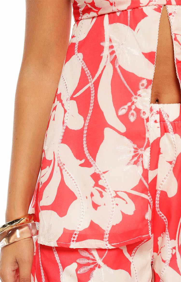 Close-up of the red and white floral longline top showing the front split and white embroidered details