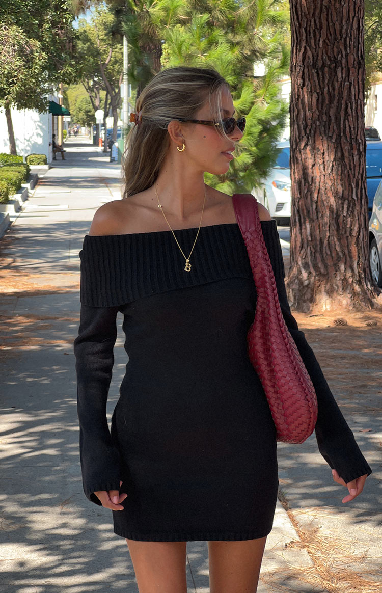 Side view of a black off-shoulder long sleeve mini dress with a ribbed neckline