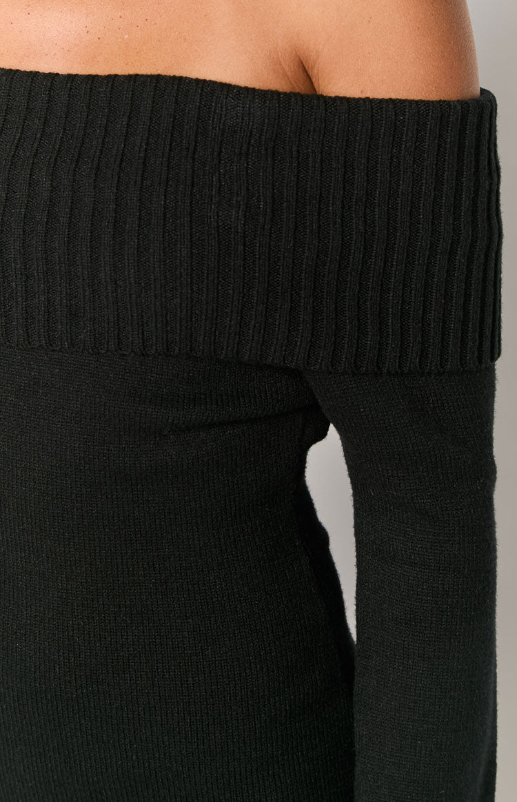 Close-up showing the ribbed off-shoulder neckline and the fine knit long sleeve of a black mini dress