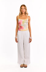 Front view of a yellow sequin tank top with large pink and white floral pattern and thin spaghetti straps