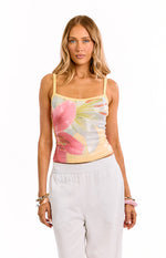 Front view of a yellow sequin tank top with large pink and white floral pattern and thin spaghetti straps