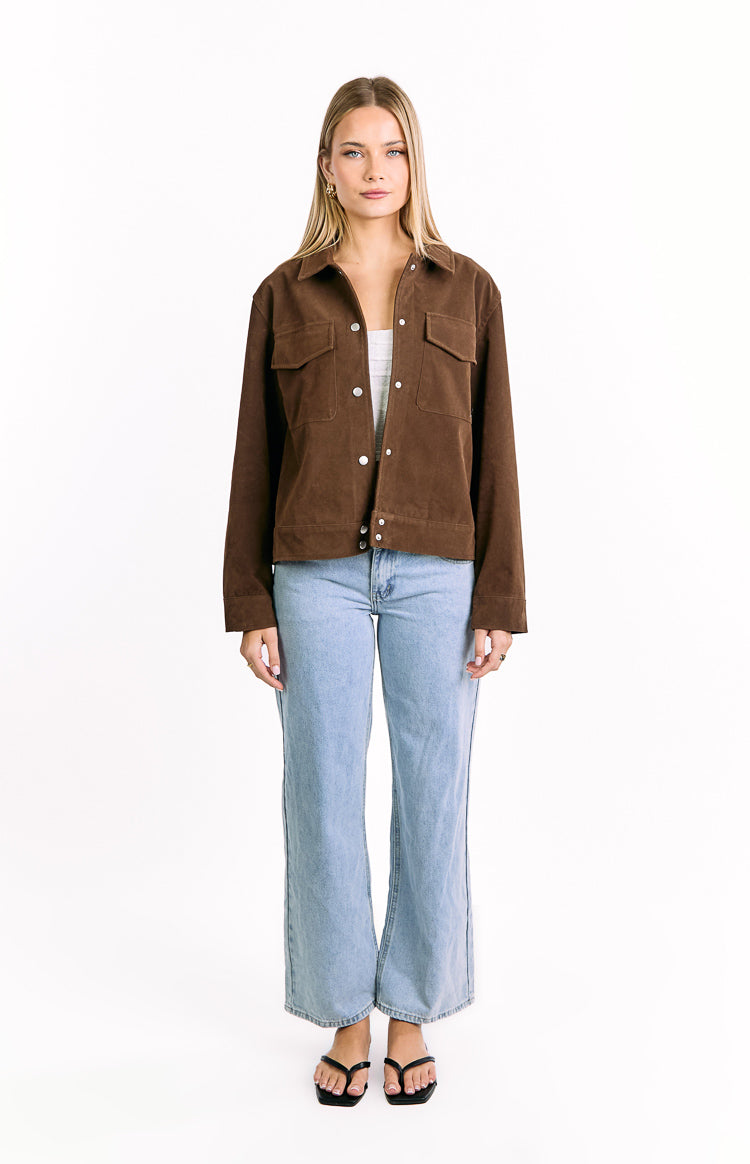 Front view of a chocolate brown suedette jacket worn open, showing the collar and two chest flap pockets