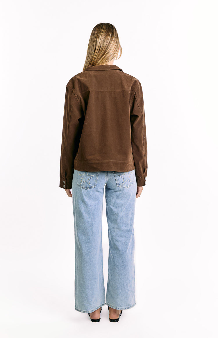Rear view of a chocolate brown suedette jacket with a relaxed fit, collared neckline, and buttoned cuffs