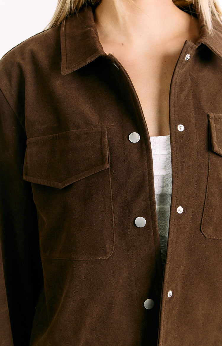 Close-up of the chocolate brown suedette jacket showing the pointed collar, silver snap buttons, and chest pockets