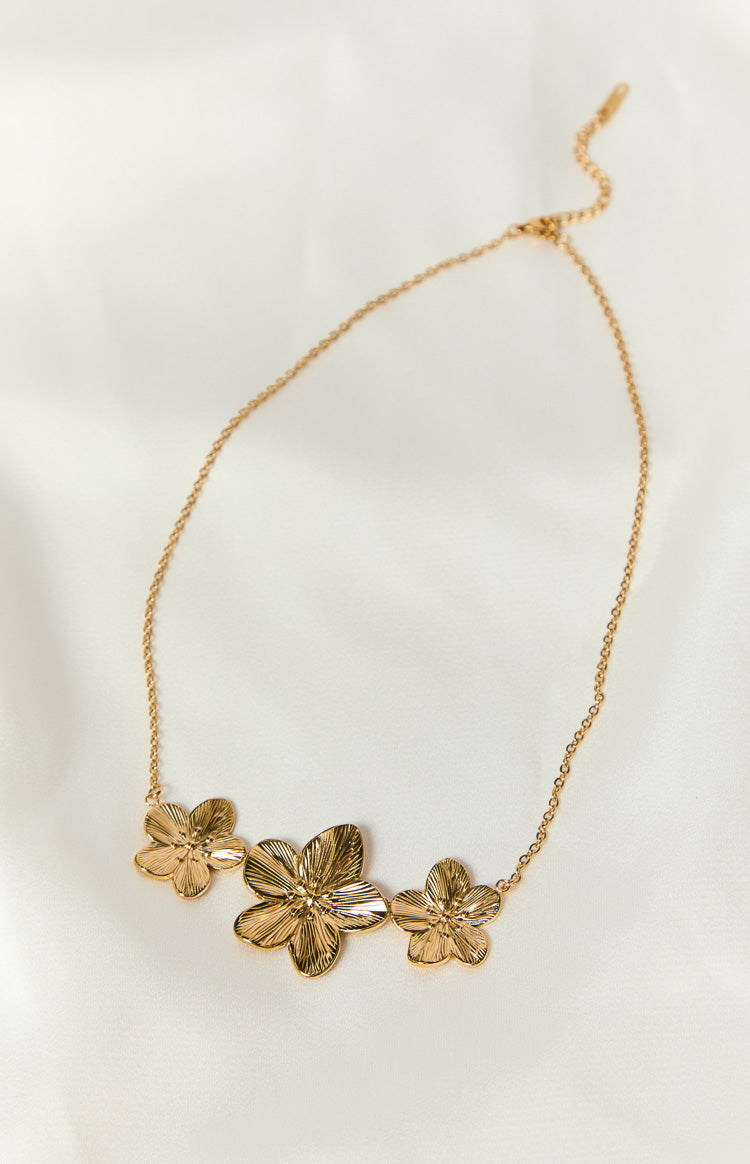 Textured gold frangipani flower charms on a delicate link necklace with an adjustable clasp