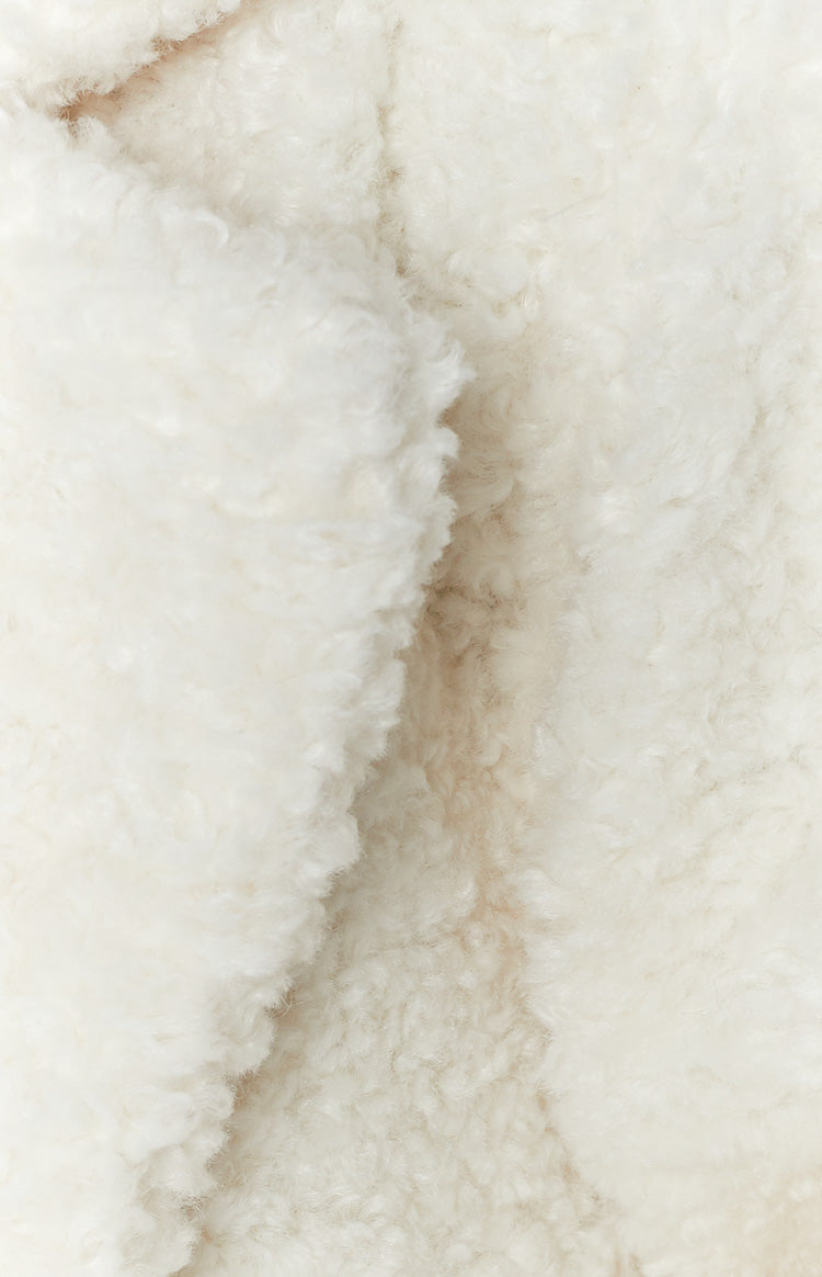 Close-up of the soft white teddy fabric of the coat, highlighting its fluffy texture
