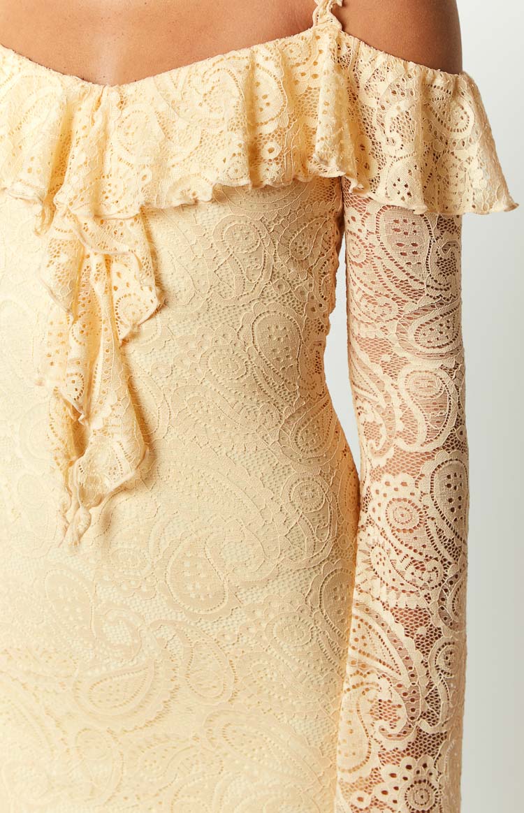 Close-up of the cream lace mini dress with intricate paisley pattern, off-shoulder ruffle, and long sleeve