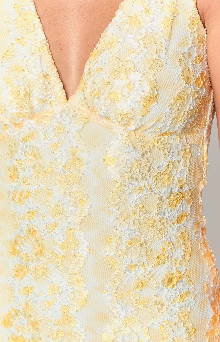 Intricate yellow and white floral lace fabric detail with a deep V-neckline on the mini dress