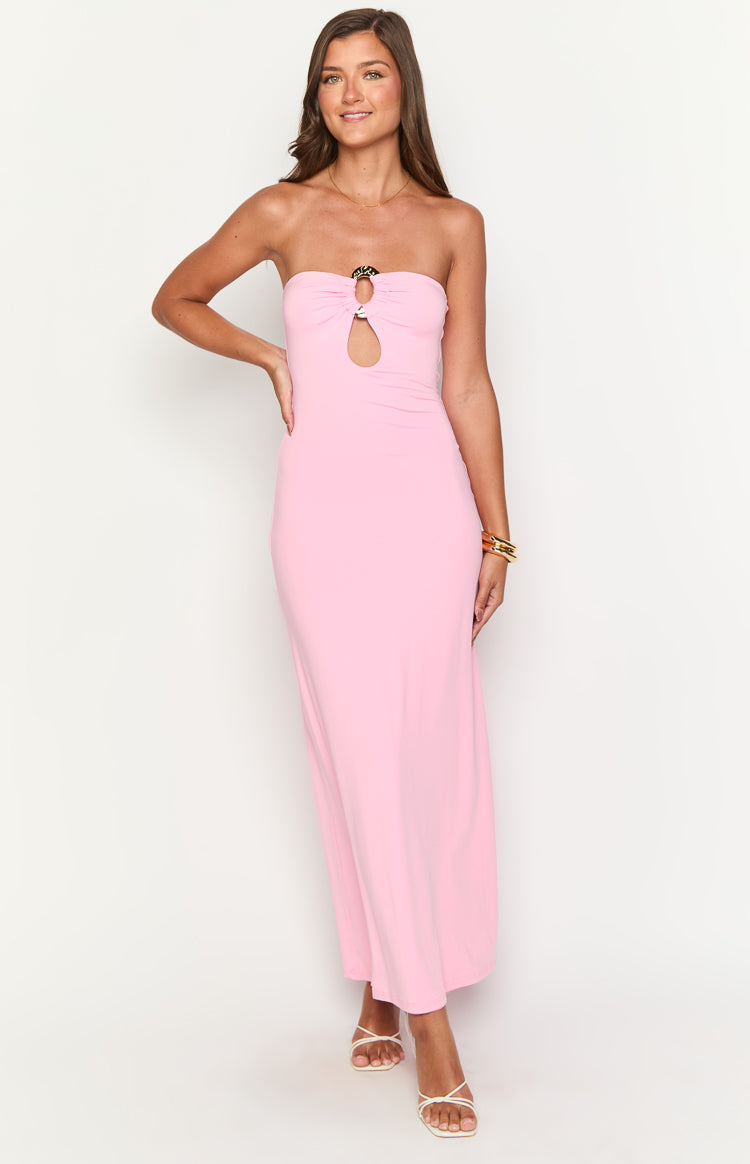 Front view of a pink strapless maxi dress with a gold and black ring detail and bust cutout