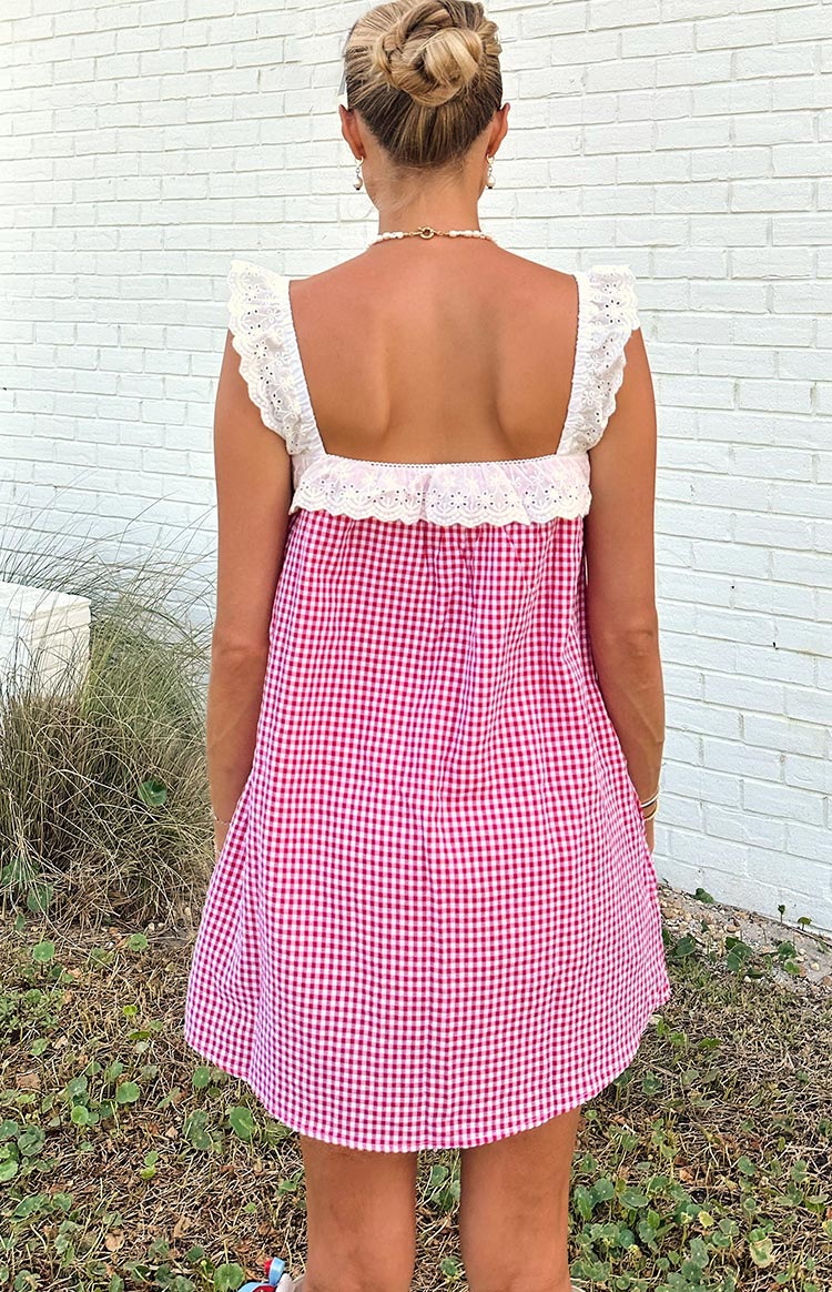 Rear view of a red gingham mini dress with white broderie anglaise ruffled straps and a square back neckline