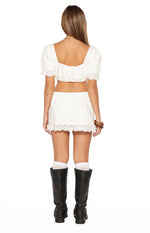 Rear view of a white crop top with a square back neckline, elasticated hem, and short puff sleeves with broderie trim