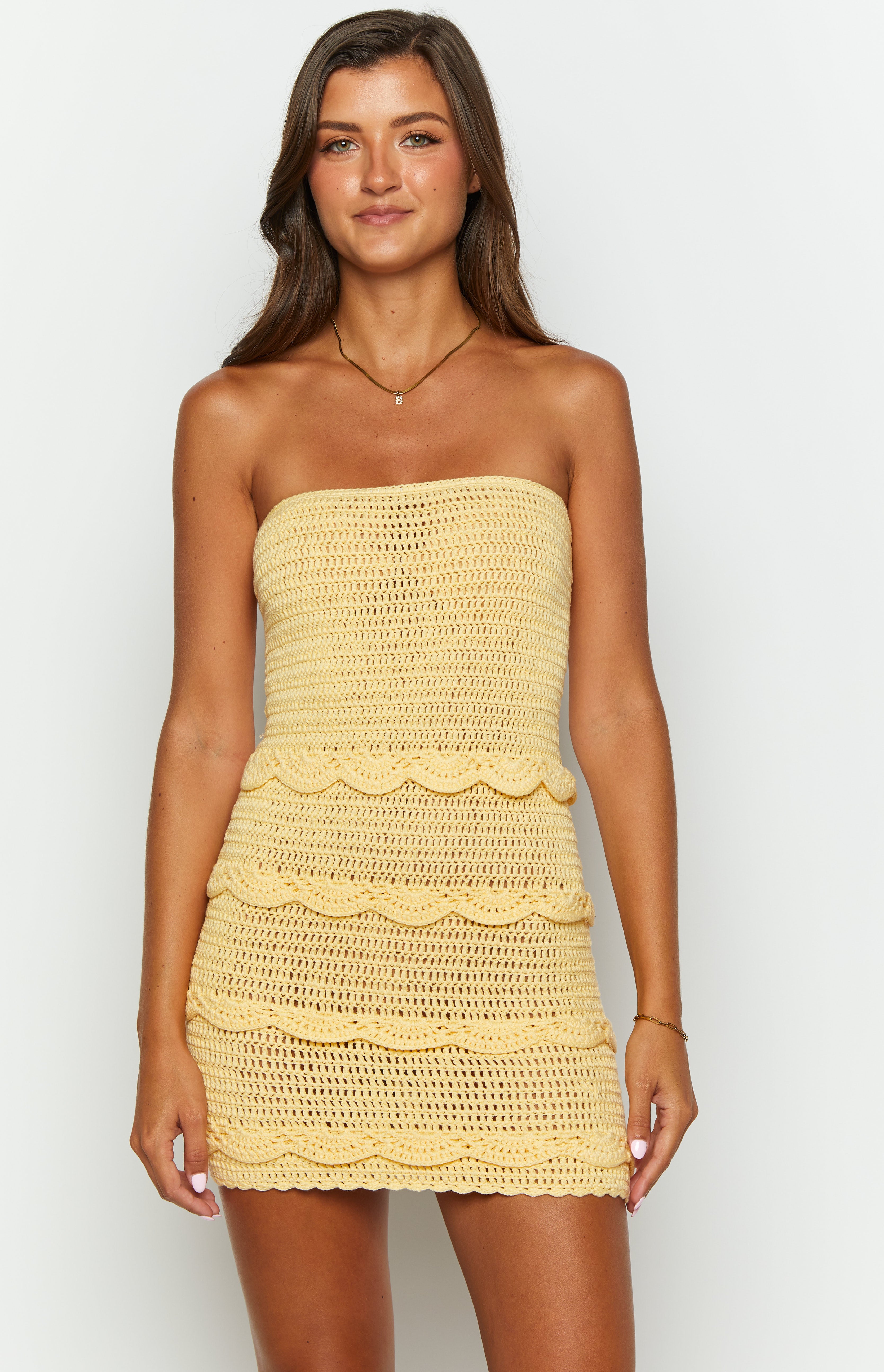 Yellow crochet mini dress with open knit texture and scalloped tiered design