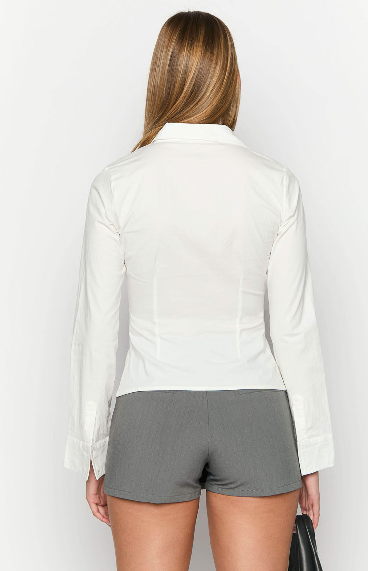 Back view of a white fitted long sleeve shirt with vertical tailored seams and wide buttoned cuffs
