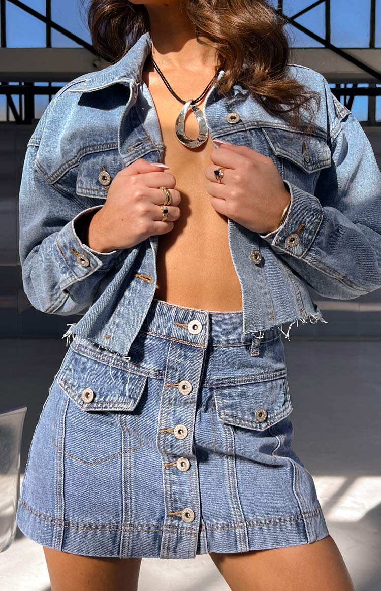 Beginning Boutique Helena Mid Wash Denim Cargo Mini Skirt mid wash denim cargo mini skirt with button front and flap pockets