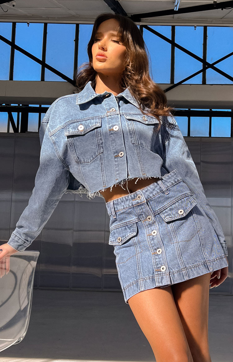 Beginning Boutique Helena Mid Wash Denim Cropped Jacket mid wash denim collared long sleeve button-front with chest pockets and raw hem