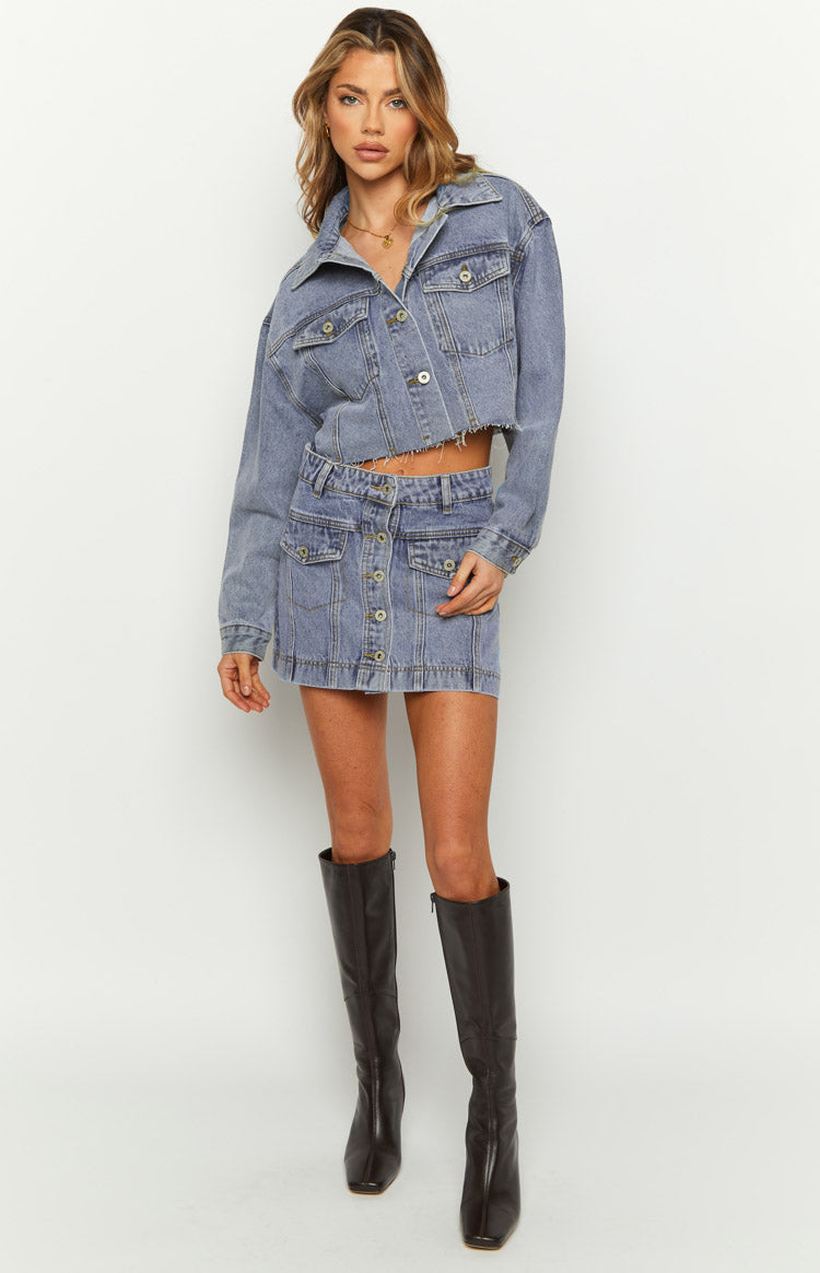 Mid wash denim cargo mini skirt with a button-front closure and prominent flap pockets