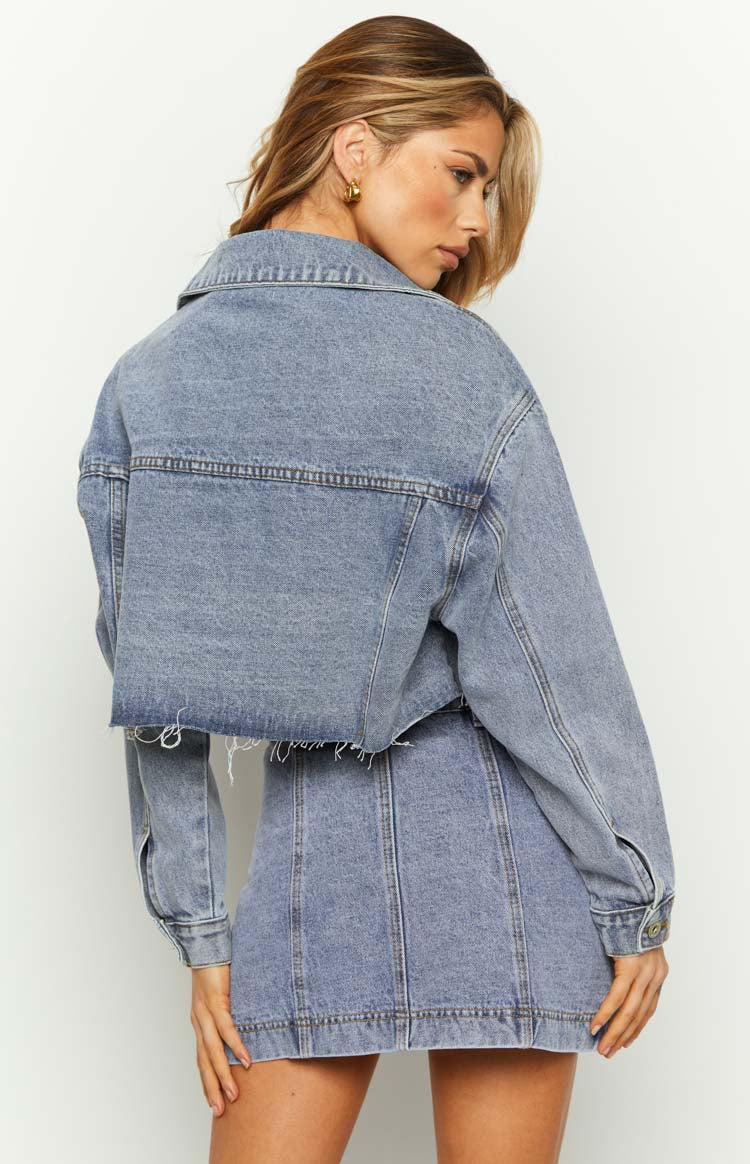 Rear view of a mid-wash denim mini skirt with prominent vertical seam detailing on the back