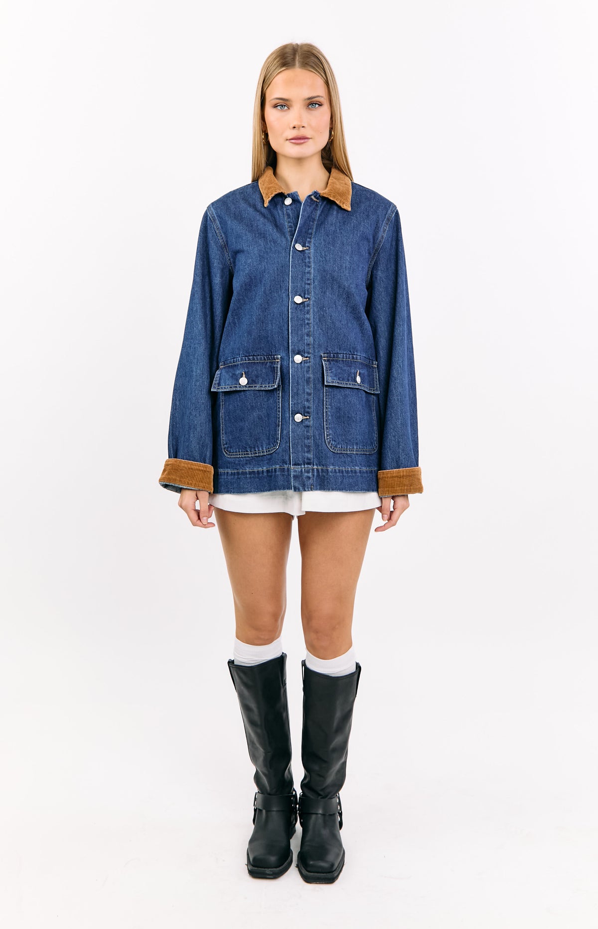 Front view of a mid wash denim oversized jacket with a brown corduroy collar and cuffs, and large patch pockets